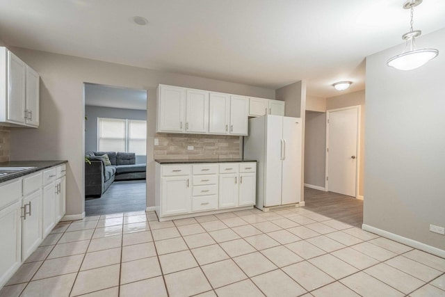 1745 N 40th Ave, Stone Park, IL 60165 - kitchen featuring freestanding refrigerator, decorative backsplash, dark countertops, white cabinets, and decorative light fixtures