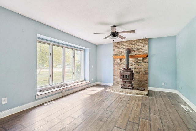 1888 Irene Rd, Sandwich, IL 60548 - unfurnished living room with wood finished floors, a wood stove, and ceiling fan