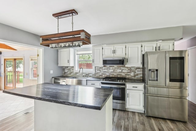 1888 Irene Rd, Sandwich, IL 60548 - kitchen featuring appliances with stainless steel finishes, dark countertops, backsplash, wood finished floors, and white cabinetry