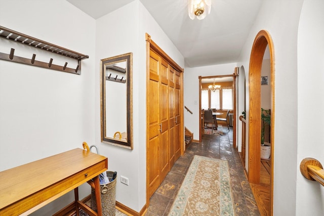 7542 Mason Ave, Burbank, IL 60459 - hall featuring a chandelier, arched walkways, and dark stone finish floors