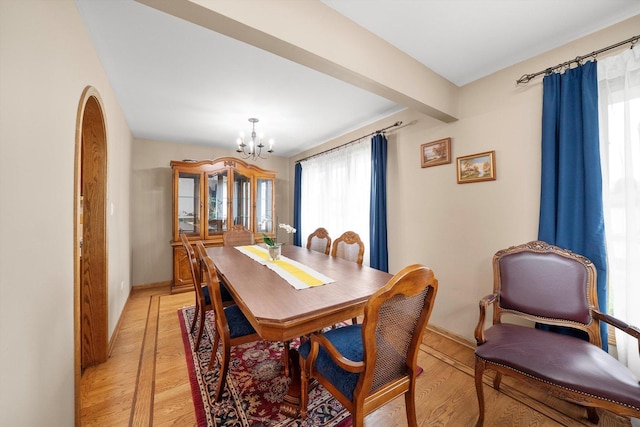 7542 Mason Ave, Burbank, IL 60459 - dining area with healthy amount of natural light, a chandelier, light wood-style flooring, and arched walkways