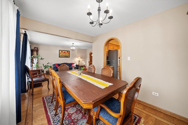7542 Mason Ave, Burbank, IL 60459 - dining space with a chandelier, arched walkways, and light wood-style floors
