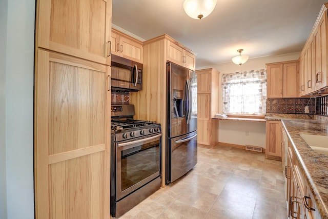 1806 New High St, Rock Falls, IL 61071 - kitchen featuring appliances with stainless steel finishes, light brown cabinetry, backsplash, and dark stone countertops