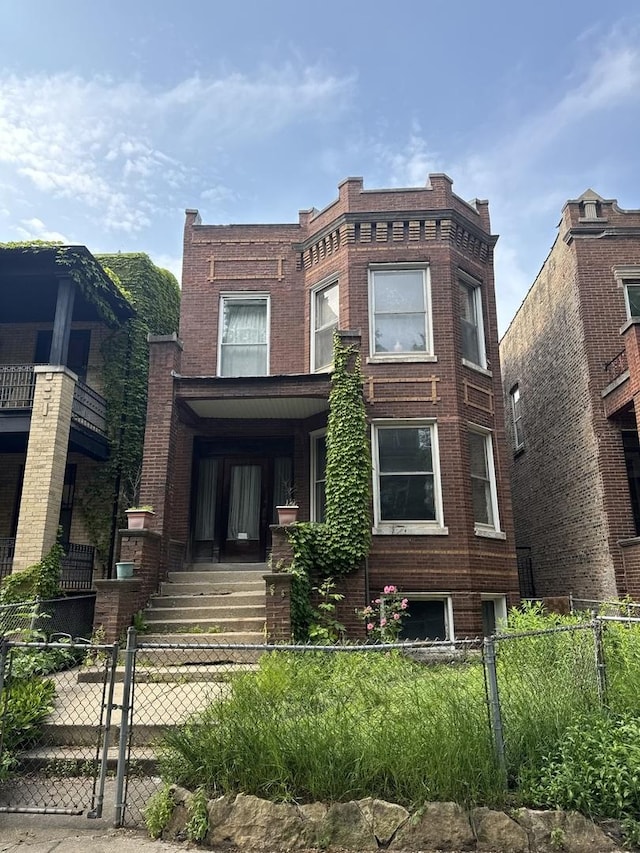 2130 W Concord Pl, Chicago, IL 60647 - front facade with a fenced front yard and brick siding