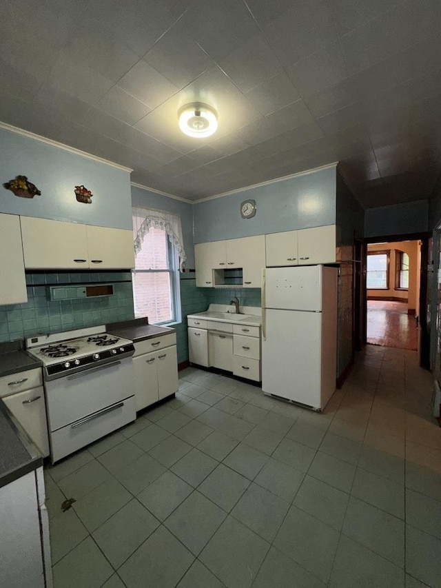 2130 W Concord Pl, Chicago, IL 60647 - kitchen with white appliances, white cabinetry, dark countertops, tile patterned floors, and ornamental molding