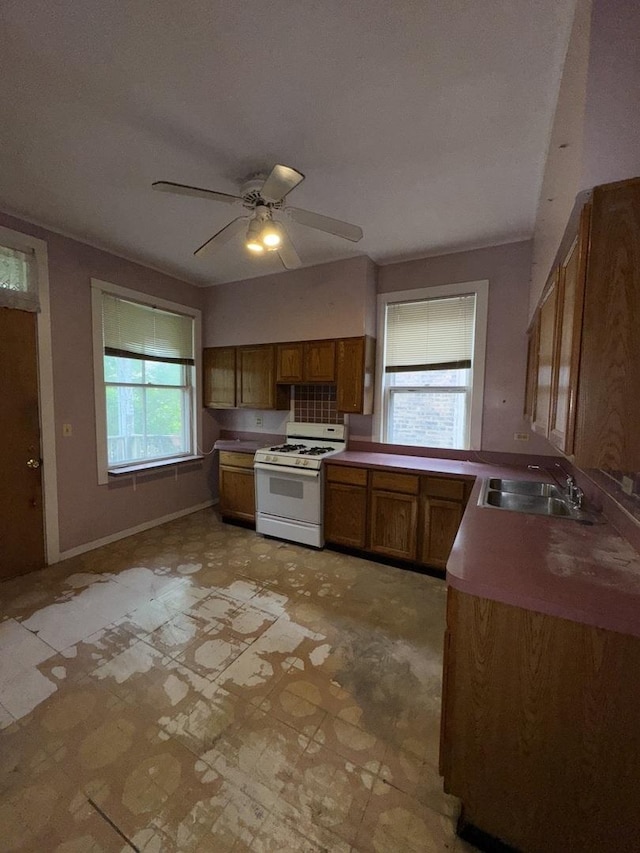 2130 W Concord Pl, Chicago, IL 60647 - kitchen featuring white range with gas stovetop, brown cabinets, a ceiling fan, and light flooring