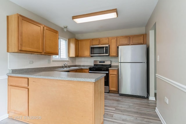 5S730 Malibu Ln, Naperville, IL 60540 - kitchen featuring stainless steel appliances, a peninsula, decorative backsplash, and light wood-style floors