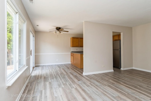 5S730 Malibu Ln, Naperville, IL 60540 - unfurnished living room featuring healthy amount of natural light, light wood-type flooring, and ceiling fan