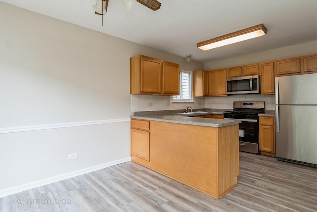 5S730 Malibu Ln, Naperville, IL 60540 - kitchen with stainless steel appliances, light wood finished floors, a peninsula, a ceiling fan, and backsplash