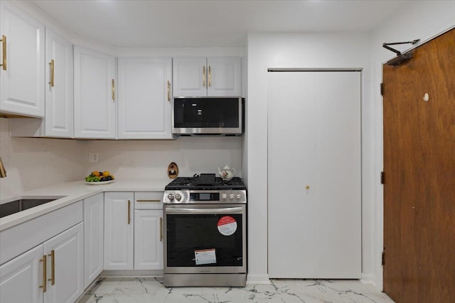 8916 Kenneth Dr Unit 1E, Des Plaines, IL 60016 - kitchen featuring appliances with stainless steel finishes, light marble finish floors, white cabinetry, and light countertops