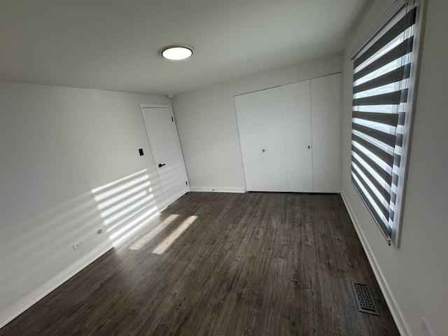 1805 Marquette Ln, Hoffman Estates, IL 60169 - unfurnished bedroom featuring dark wood-style flooring, multiple windows, and a closet