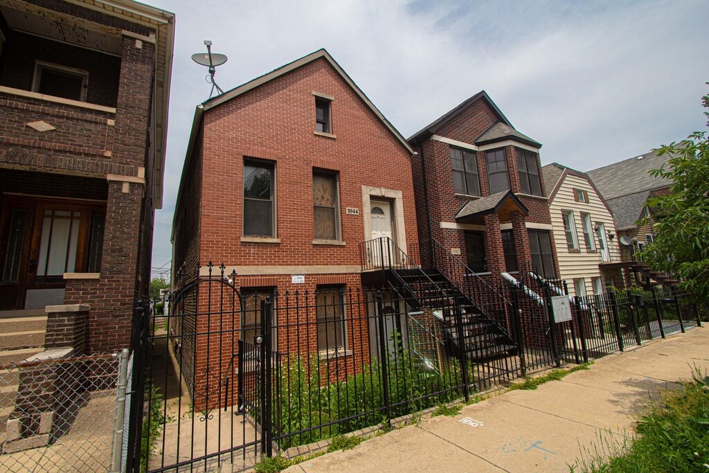1044 W 34th Pl, Chicago, IL 60608 - multi unit property with a fenced front yard, brick siding, and a gate