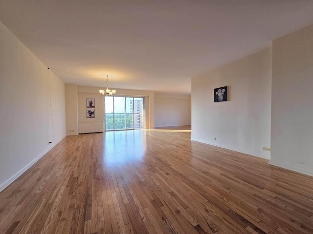 6833 N Kedzie Ave Unit 816, Chicago, IL 60645 - spare room with a chandelier and hardwood / wood-style floors