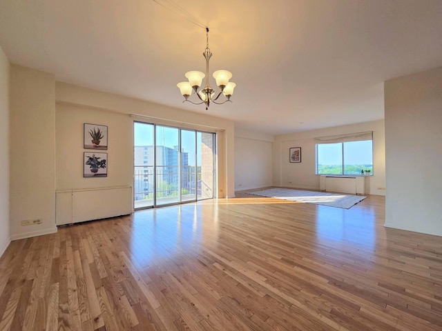 6833 N Kedzie Ave Unit 816, Chicago, IL 60645 - unfurnished room featuring a chandelier and wood finished floors