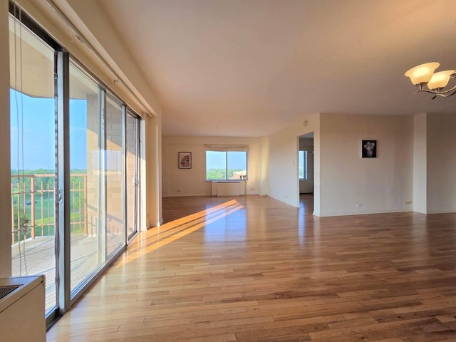 6833 N Kedzie Ave Unit 816, Chicago, IL 60645 - empty room with light wood-style floors and a chandelier