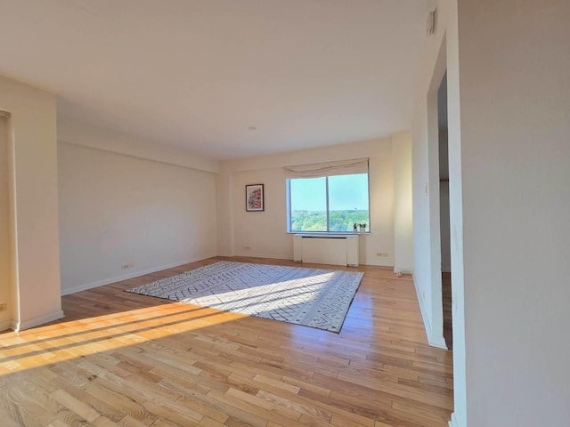 6833 N Kedzie Ave Unit 816, Chicago, IL 60645 - empty room with wood finished floors and radiator heating unit