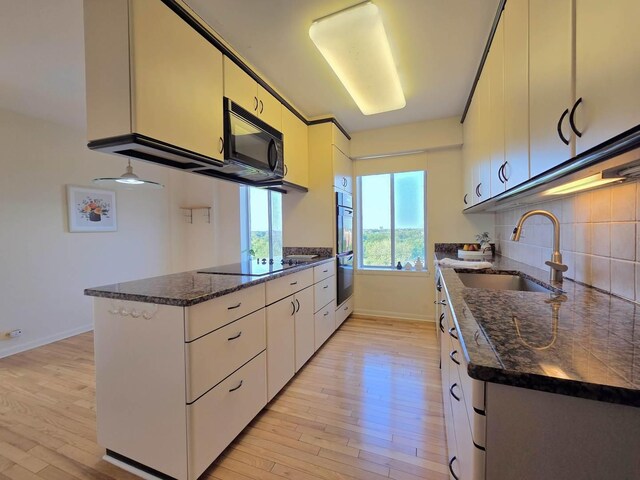 6833 N Kedzie Ave Unit 816, Chicago, IL 60645 - kitchen with black appliances, light wood-style floors, decorative backsplash, and a peninsula
