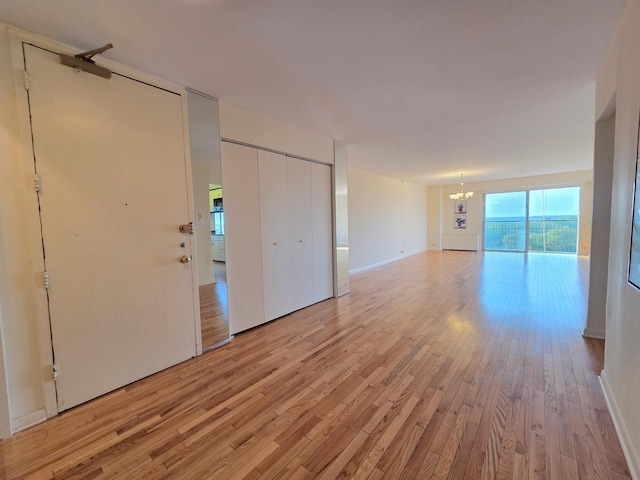 6833 N Kedzie Ave Unit 816, Chicago, IL 60645 - empty room with a chandelier and light wood-type flooring