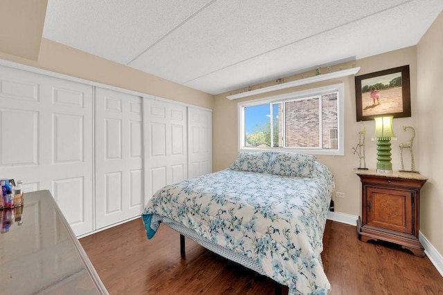 5848 W 76th Pl N Unit 203, Burbank, IL 60459 - bedroom with dark wood finished floors, a closet, and a textured ceiling