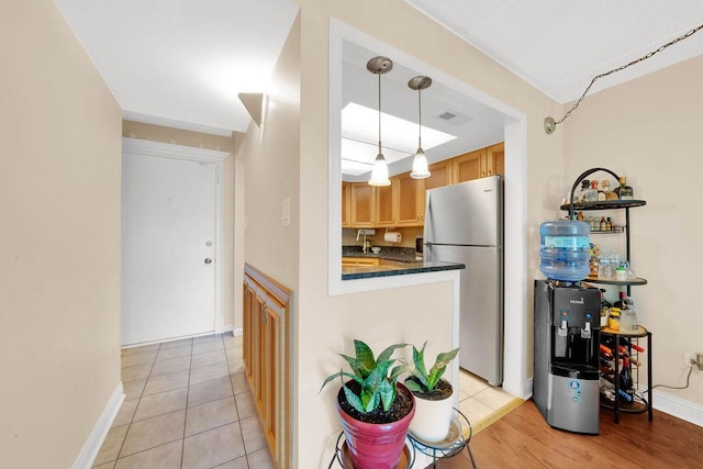 5848 W 76th Pl N Unit 203, Burbank, IL 60459 - kitchen featuring freestanding refrigerator, dark countertops, pendant lighting, and light tile patterned floors