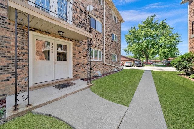 5848 W 76th Pl N Unit 203, Burbank, IL 60459 - entrance to property featuring brick siding, a yard, and a balcony