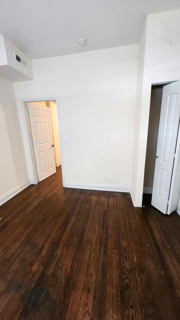 6938 S Michigan Ave, Chicago, IL 60637 - unfurnished room featuring dark wood finished floors and baseboards