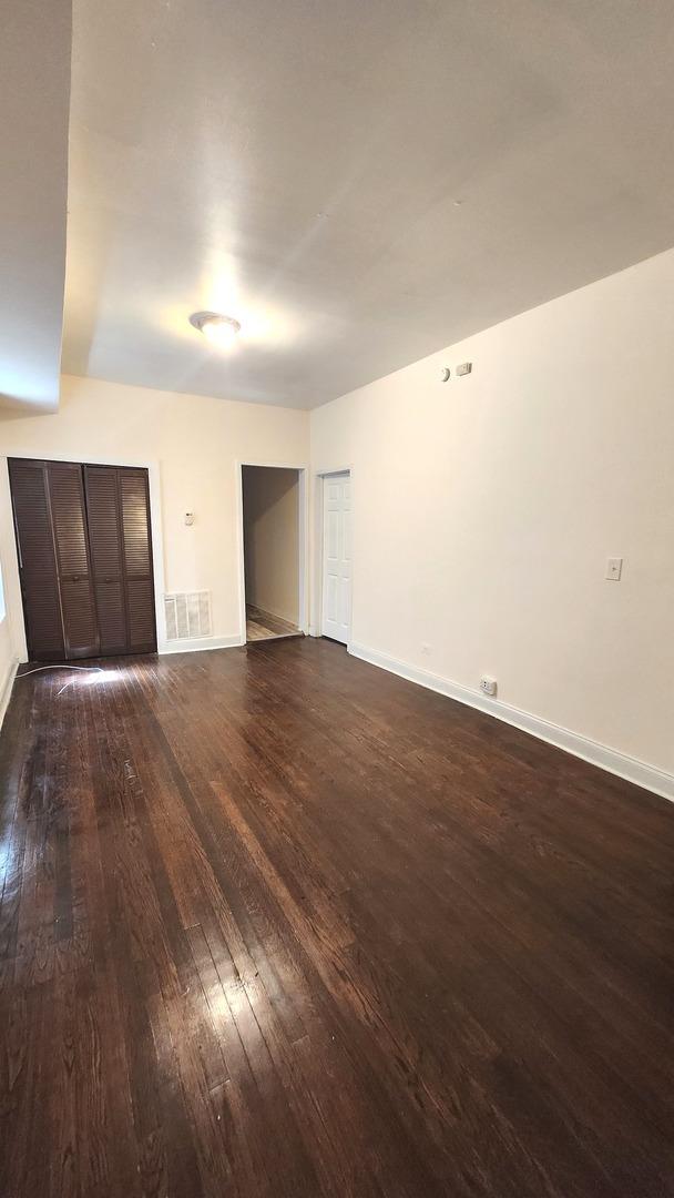 6938 S Michigan Ave, Chicago, IL 60637 - unfurnished room featuring dark wood-style floors and baseboards