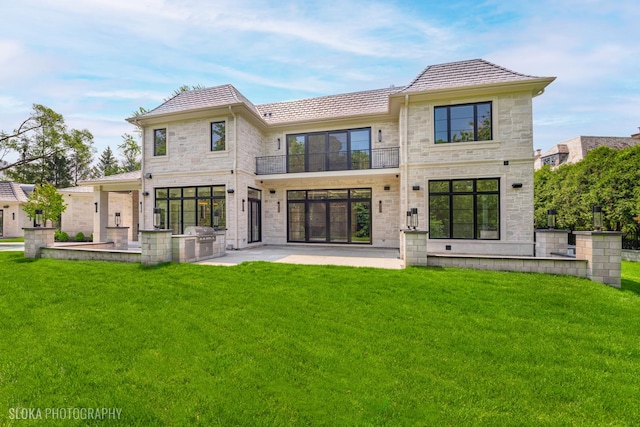 219 Lincoln Dr, Glencoe, IL 60022 - back of house with a balcony, a patio, stone siding, and a lawn