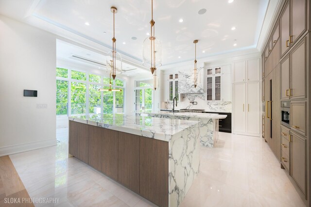 219 Lincoln Dr, Glencoe, IL 60022 - kitchen featuring a large island, backsplash, light stone counters, glass insert cabinets, and recessed lighting