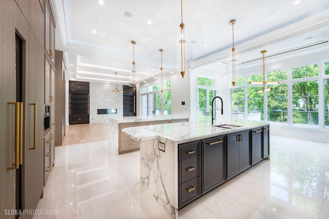 219 Lincoln Dr, Glencoe, IL 60022 - kitchen with a spacious island, light stone countertops, pendant lighting, light marble finish floors, and open floor plan