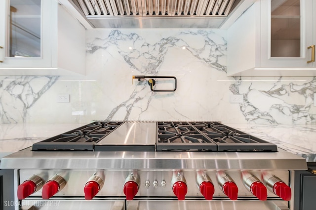 219 Lincoln Dr, Glencoe, IL 60022 - kitchen with stainless steel stove, custom exhaust hood, tasteful backsplash, and glass insert cabinets