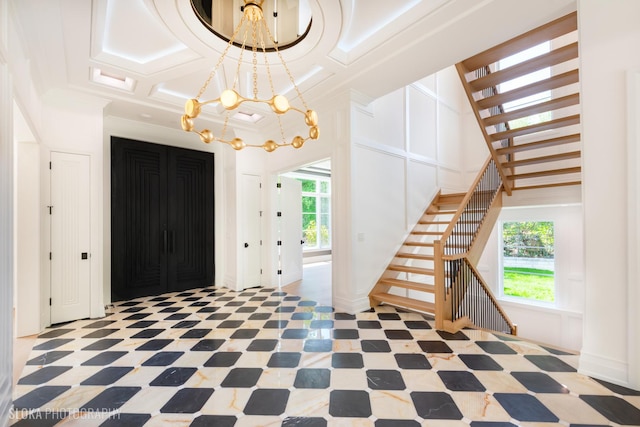 219 Lincoln Dr, Glencoe, IL 60022 - foyer with a chandelier, stairs, crown molding, and coffered ceiling