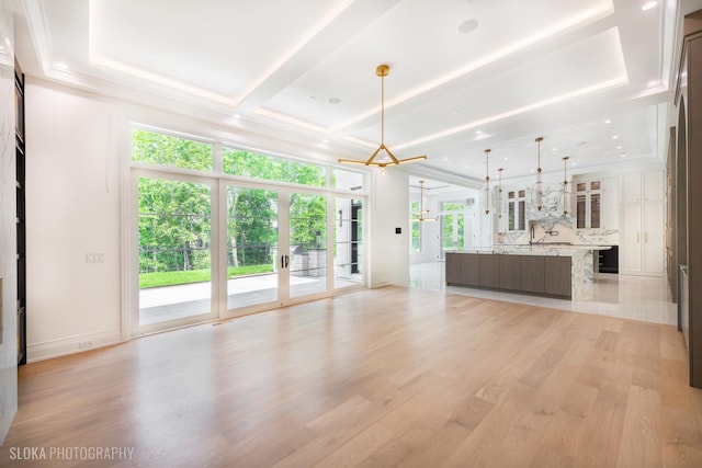 219 Lincoln Dr, Glencoe, IL 60022 - unfurnished living room with plenty of natural light, a chandelier, light wood-style flooring, french doors, and coffered ceiling
