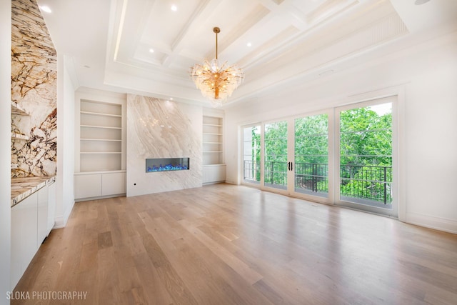 219 Lincoln Dr, Glencoe, IL 60022 - unfurnished living room with built in shelves, light wood-type flooring, a chandelier, a premium fireplace, and ornamental molding