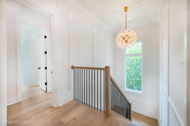219 Lincoln Dr, Glencoe, IL 60022 - corridor featuring a decorative wall, a chandelier, an upstairs landing, light wood finished floors, and crown molding
