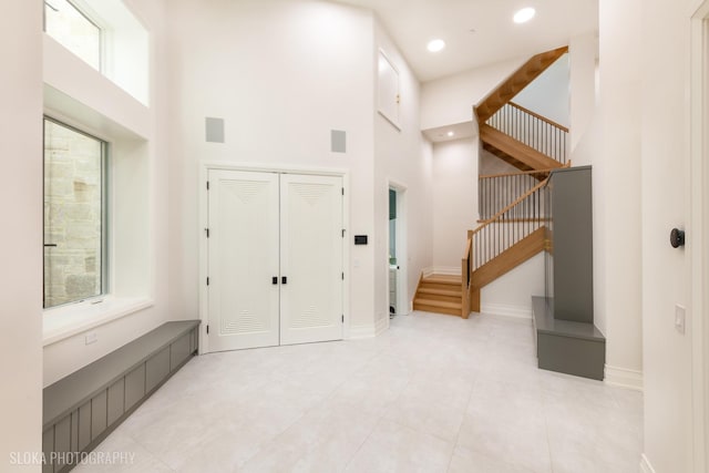 219 Lincoln Dr, Glencoe, IL 60022 - entrance foyer with a high ceiling, stairway, healthy amount of natural light, light tile patterned flooring, and recessed lighting