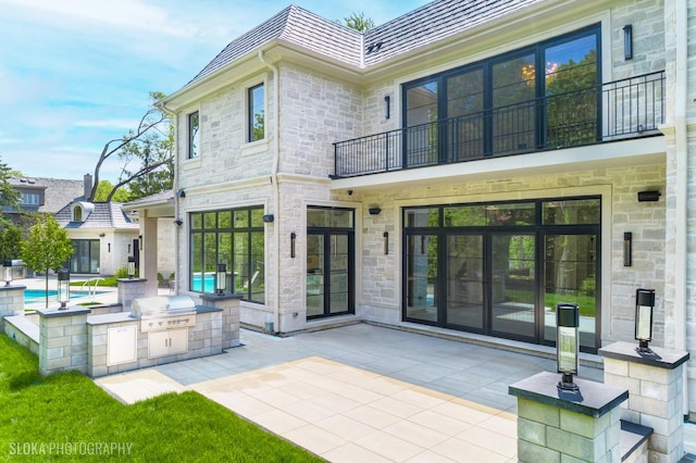 219 Lincoln Dr, Glencoe, IL 60022 - rear view of property with area for grilling, a balcony, stone siding, and a patio