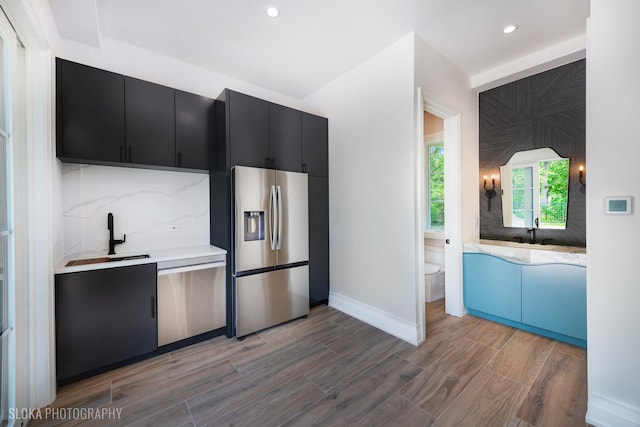 219 Lincoln Dr, Glencoe, IL 60022 - kitchen with appliances with stainless steel finishes, dark cabinetry, decorative backsplash, light countertops, and recessed lighting