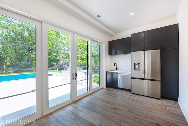 219 Lincoln Dr, Glencoe, IL 60022 - kitchen with stainless steel appliances, dark cabinets, light countertops, light wood-style flooring, and recessed lighting