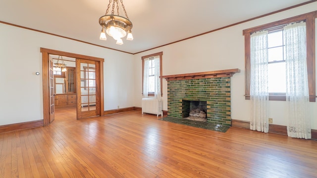 531 E Joliet St, Crown Point, IN 46307 - unfurnished living room with radiator heating unit, a chandelier, light wood-style flooring, crown molding, and a brick fireplace