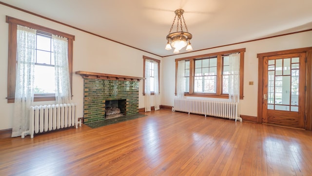 531 E Joliet St, Crown Point, IN 46307 - unfurnished living room with radiator heating unit, hardwood / wood-style flooring, healthy amount of natural light, and crown molding