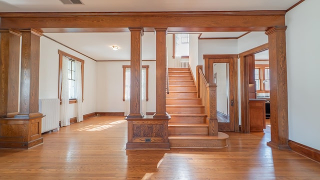531 E Joliet St, Crown Point, IN 46307 - staircase with radiator, decorative columns, plenty of natural light, crown molding, and hardwood / wood-style flooring