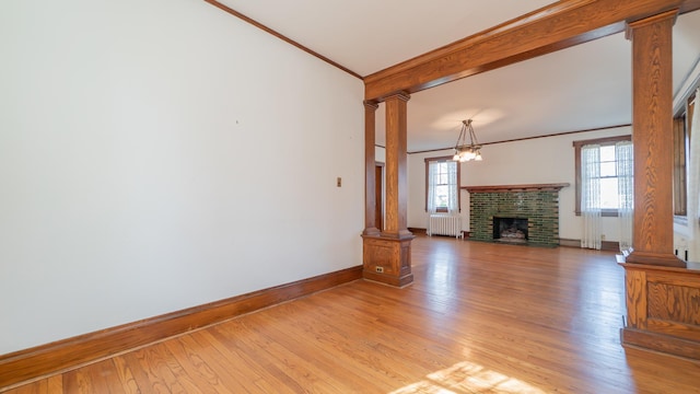 531 E Joliet St, Crown Point, IN 46307 - unfurnished living room featuring decorative columns, radiator, ornamental molding, light wood-style floors, and a fireplace
