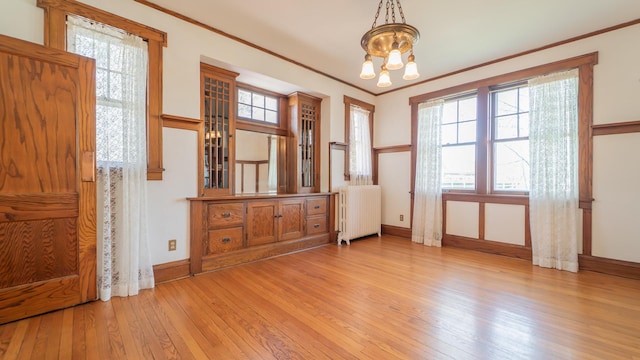 531 E Joliet St, Crown Point, IN 46307 - entrance foyer featuring radiator, a chandelier, light wood finished floors, healthy amount of natural light, and crown molding