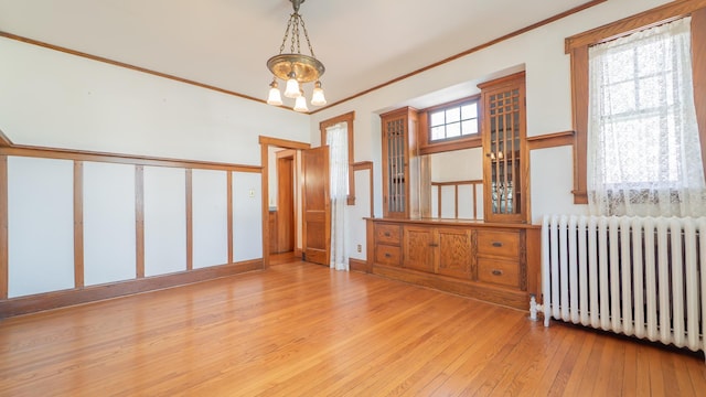 531 E Joliet St, Crown Point, IN 46307 - empty room featuring radiator, a chandelier, hardwood / wood-style floors, and crown molding