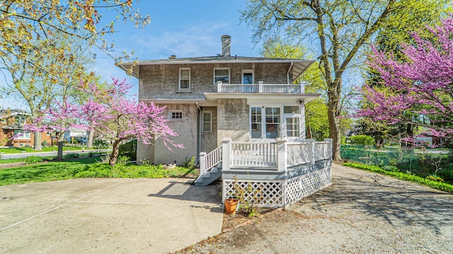 531 E Joliet St, Crown Point, IN 46307 - view of front of property with a balcony, a chimney, and stucco siding