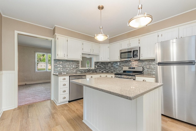 609 Oakwood Dr, Grayslake, IL 60030 - kitchen featuring appliances with stainless steel finishes, light wood-style floors, ornamental molding, a center island, and white cabinets