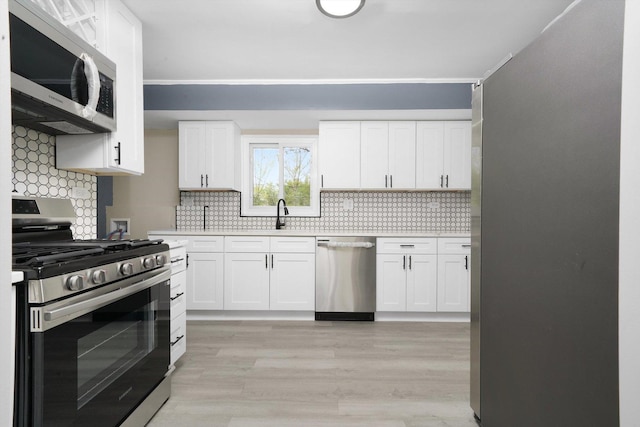 202 Allegheny St, Park Forest, IL 60466 - kitchen featuring stainless steel appliances, light wood-style floors, decorative backsplash, white cabinetry, and light countertops