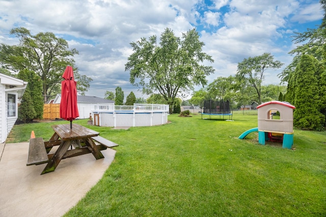 16430 S 89th Ave, Orland Park, IL 60462 - view of grassy yard featuring a trampoline, an outdoor pool, outdoor dining space, a patio area, and a playground