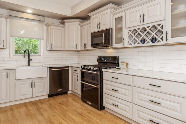 835 W 37th St Unit A, Chicago, IL 60609 - kitchen featuring black microwave, range with two ovens, dishwasher, light stone counters, and recessed lighting
